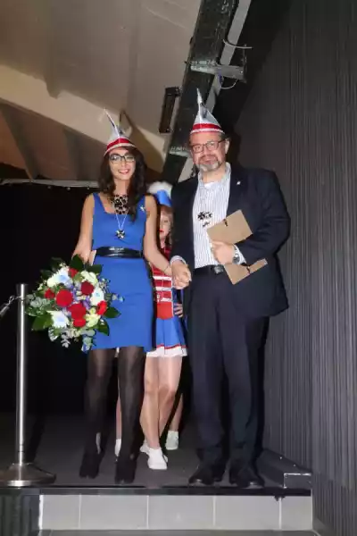 Feierliche Ernennung von Inas und Thorsten Schulz zu Ehrensenatoren der Karnevalsgemeinschaft Eugenesen Alaaf, umgeben von Mitgliedern in festlicher Karnevalstracht.